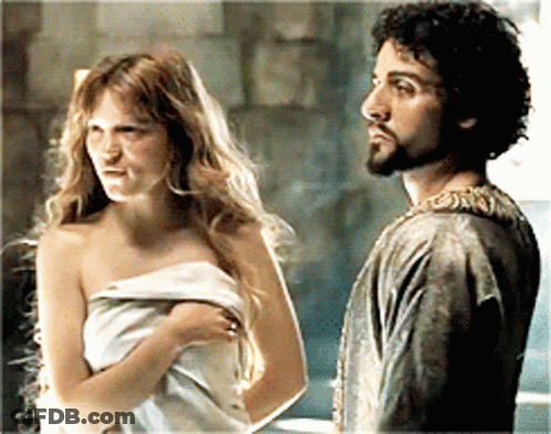 A Man And A Woman Wrapped In A Towel Are Standing Next To Each Other GIF