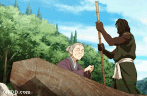 A Man And An Elderly Woman Are Standing Next To A Large Rock GIF