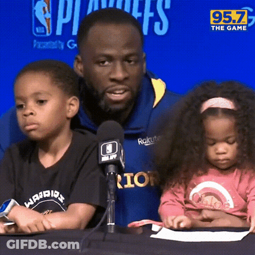 A Man And Two Children Sit In Front Of A Microphone With 95.7 The Game Written On The Bottom GIF
