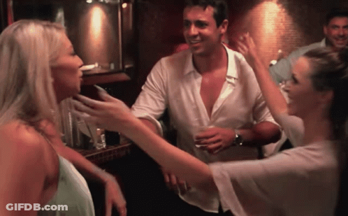 A Man And Two Women Are Dancing In A Bar GIF