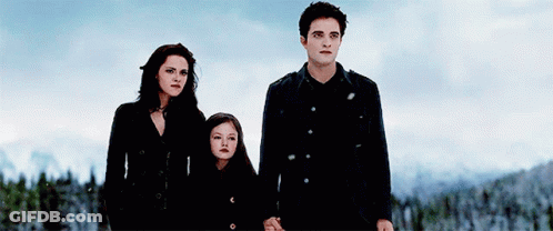 A Man And Two Women Are Standing Next To Each Other Holding Hands In The Snow . GIF
