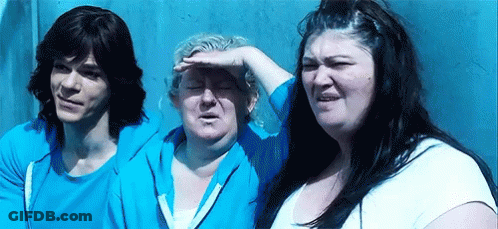 A Man And Two Women Are Standing Next To Each Other In Front Of A Wall . GIF