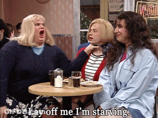 A Man And Two Women Sit At A Table With The Man Saying Lay Off Me I 'M Starving GIF