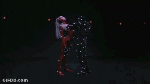 A Man And Woman Are Dancing In A Dark Room GIF