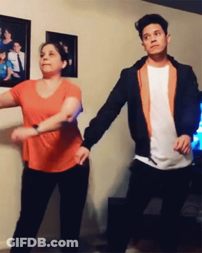 A Man And Woman Are Dancing In A Living Room GIF