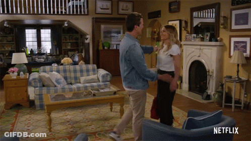 A Man And Woman Are Dancing In A Living Room With A Netflix Logo On The Bottom Right GIF