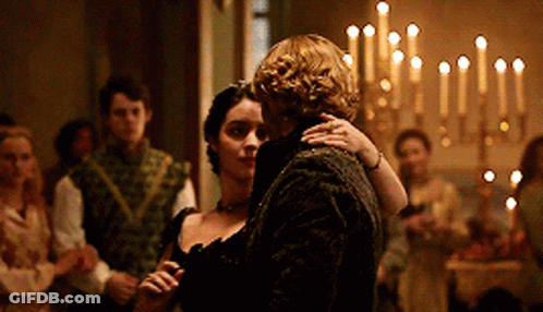 A Man And Woman Are Dancing In A Room With Candles In The Background GIF