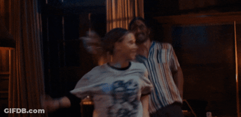 A Man And Woman Are Dancing In A Room With Lamps GIF