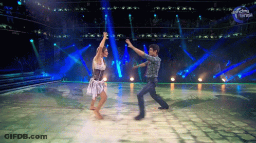 A Man And Woman Are Dancing In Front Of A Dancing Break Sign GIF