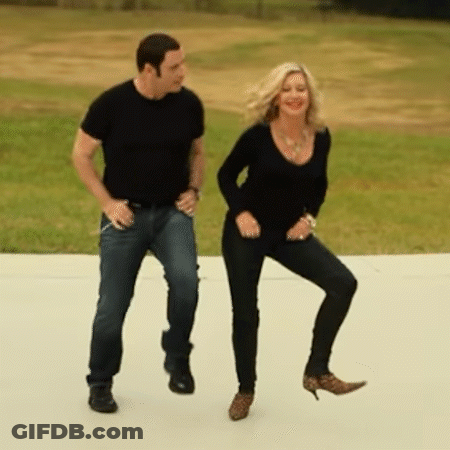 A Man And Woman Are Dancing On A Sidewalk GIF