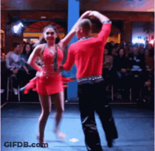 A Man And Woman Are Dancing On A Stage In Front Of A Crowd GIF