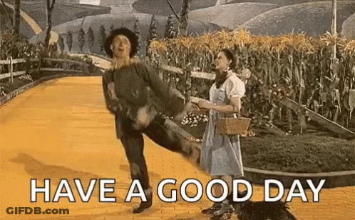 A Man And Woman Are Dancing On A Yellow Brick Road . GIF