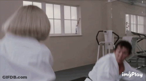 A Man And Woman Are Fighting In A Gym . GIF