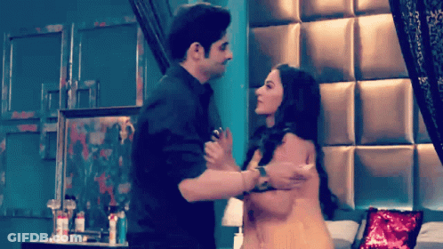 A Man And Woman Are Hugging In A Bedroom GIF