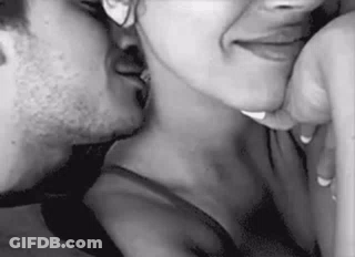 A Man And Woman Are Kissing In A Black And White Photo . GIF