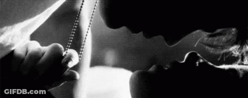A Man And Woman Are Kissing In A Black And White Photo . GIF