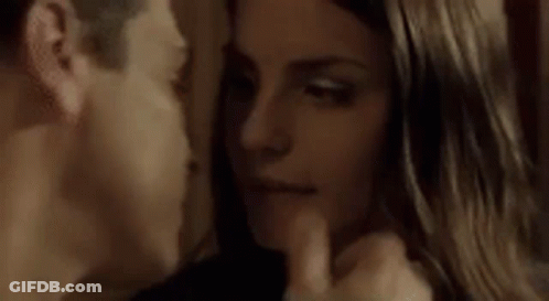 A Man And Woman Are Kissing In A Dark Room With Their Eyes Closed . GIF
