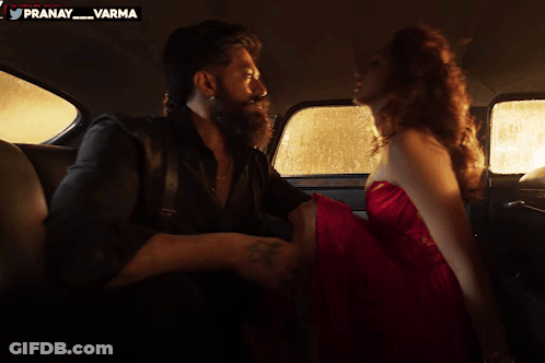 A Man And Woman Are Kissing In The Back Seat Of A Car With A Pranay Varma Logo In The Corner GIF