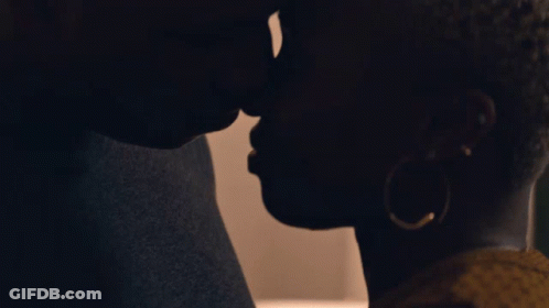 A Man And Woman Are Kissing In The Dark GIF