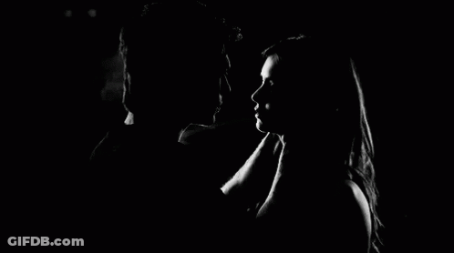 A Man And Woman Are Kissing In The Dark . GIF