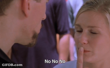 A Man And Woman Are Looking At Each Other And The Woman Is Covering Her Mouth With Her Finger And The Man Is Saying No N GIF