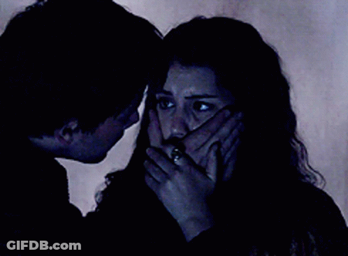 A Man And Woman Are Looking At Each Other In The Dark GIF
