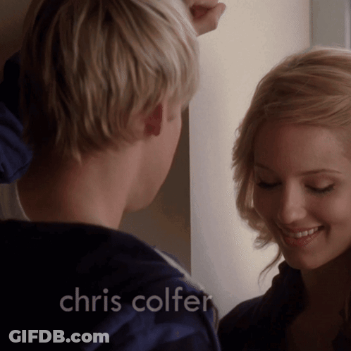 A Man And Woman Are Looking At Each Other With The Name Chris Colfer On The Bottom GIF