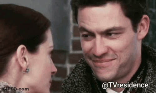 A Man And Woman Are Looking Into Each Other 'S Eyes And Smiling . GIF