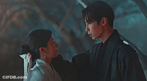A Man And Woman Are Looking Into Each Other 'S Eyes GIF