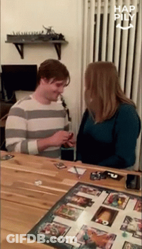 A Man And Woman Are Playing A Board Game Together . GIF