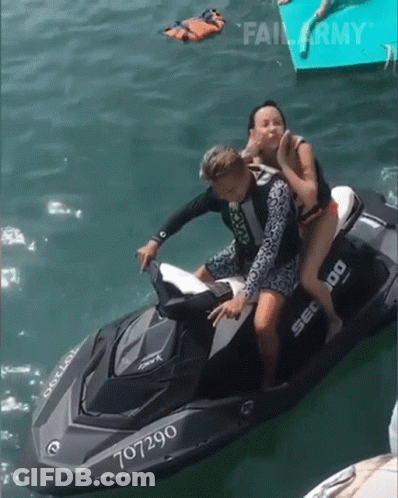 A Man And Woman Are Riding A Jet Ski With The Number 707290 GIF