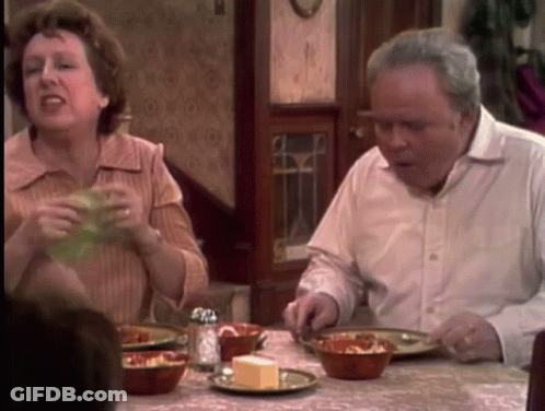 A Man And Woman Are Sitting At A Table With Bowls Of Food GIF