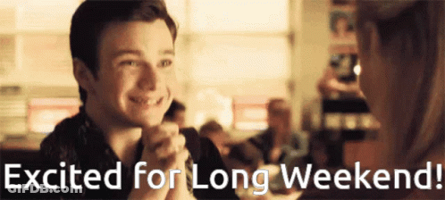 A Man And Woman Are Sitting At A Table With The Words Excited For Long Weekend Written Below Them GIF