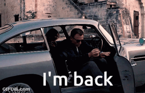 A Man And Woman Are Sitting In A Car With The Words I 'M Back On The Side GIF