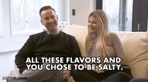A Man And Woman Are Sitting On A Couch With The Words " All These Flavors And You Chose To Be Salty " GIF
