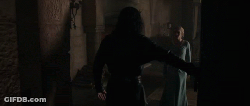 A Man And Woman Are Standing In A Dark Room GIF