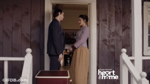 A Man And Woman Are Standing In Front Of A Door That Says Super Channel Heart And Home GIF