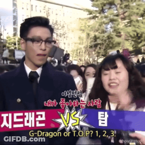 A Man And Woman Are Standing In Front Of A Sign That Says G-Dragon Or T.o.p? 1 2 3 GIF