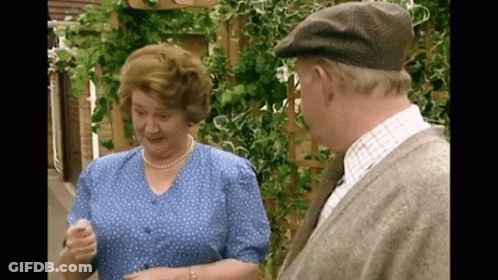 A Man And Woman Are Standing Next To Each Other And Talking GIF