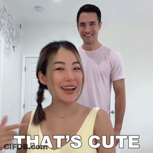 A Man And Woman Are Standing Next To Each Other And The Woman Is Pointing At The Man And Saying That 'S Cute GIF