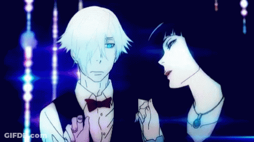 A Man And Woman Are Standing Next To Each Other In A Dark Room GIF