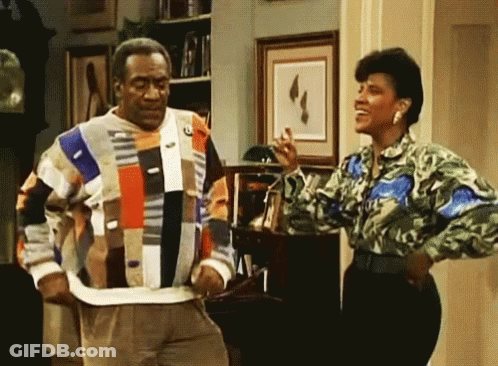 A Man And Woman Are Standing Next To Each Other In A Living Room GIF