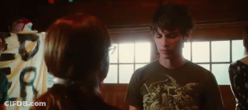 A Man And Woman Are Standing Next To Each Other In A Room . GIF