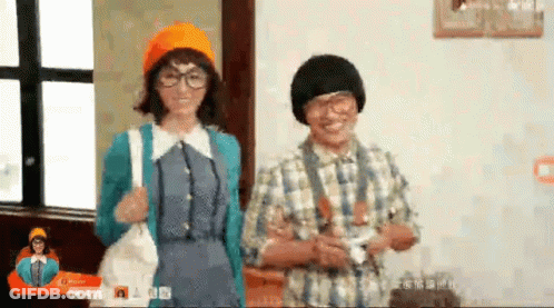 A Man And Woman Are Standing Next To Each Other In A Room . GIF