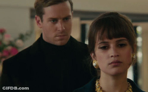 A Man And Woman Are Standing Next To Each Other GIF