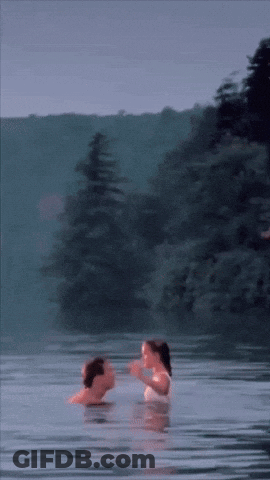 A Man And Woman Are Swimming In A Lake GIF