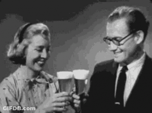 A Man And Woman Are Toasting With Beer Glasses . GIF