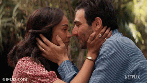 A Man And Woman Are Touching Their Foreheads With A Netflix Logo In The Background GIF