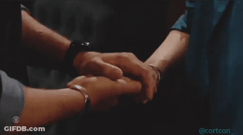 A Man And Woman Holding Hands With A Cbs Logo On The Bottom Right GIF