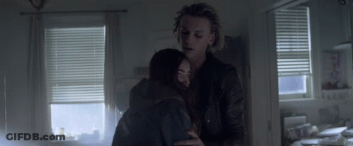 A Man And Woman Hugging In A Dark Room GIF